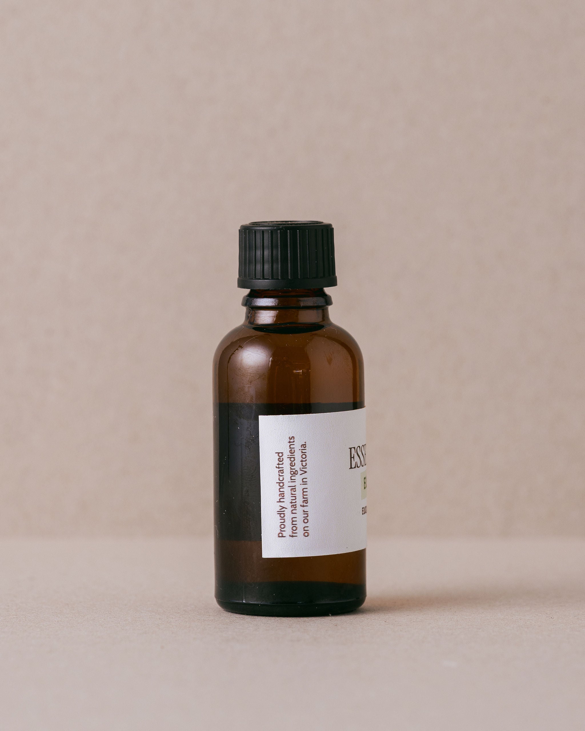 glass jar of eucalyptus blue gum essential oil on a beige background