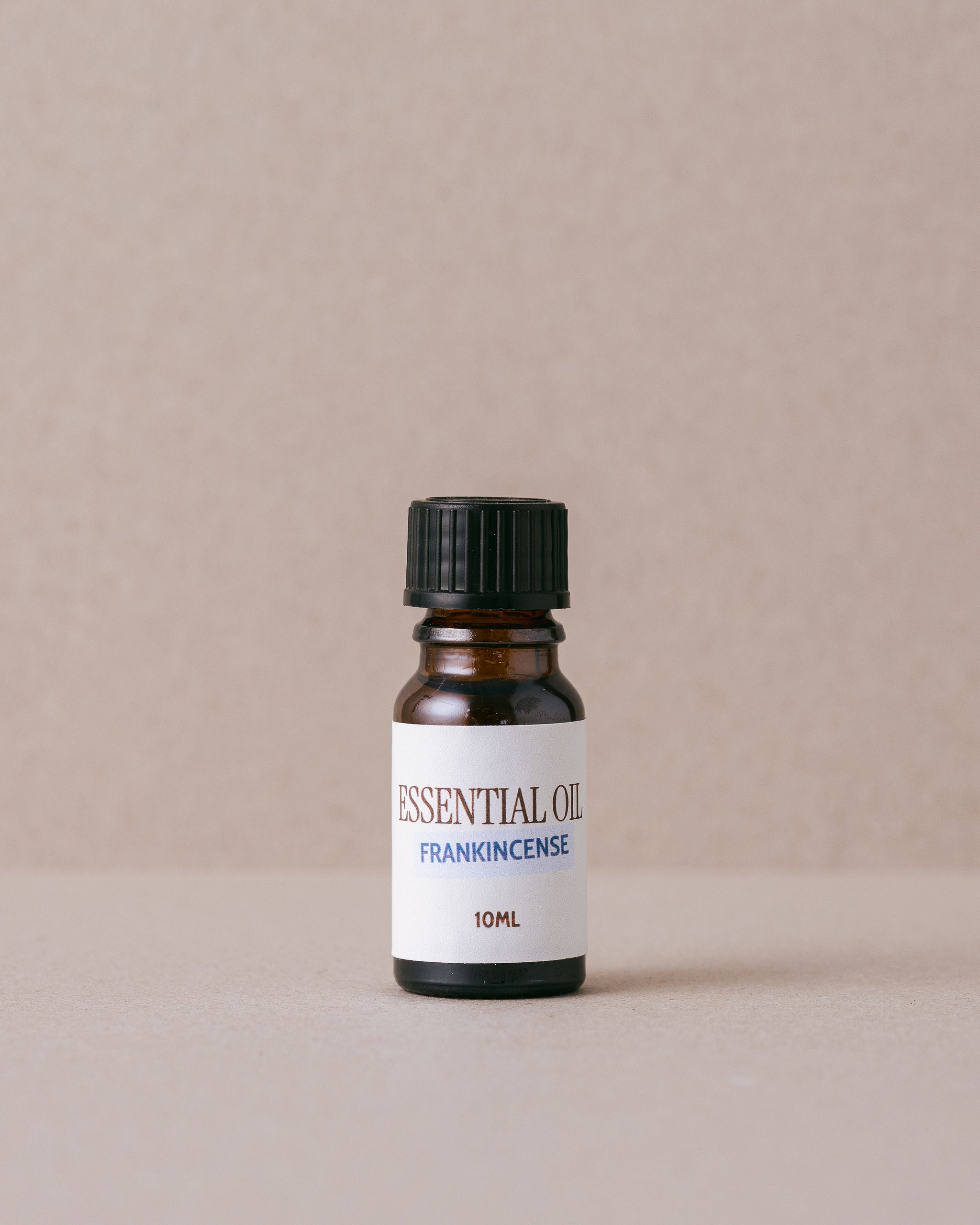 bottle of frankincense essential oil on a beige background