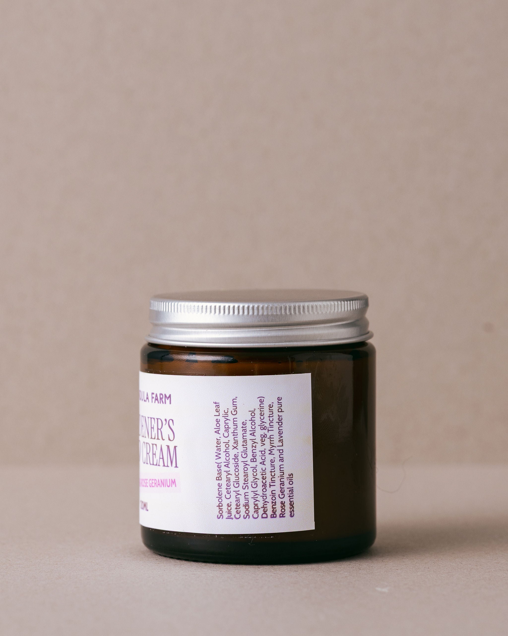 small glass jar of hand cream made with natural ingredients on a beige background