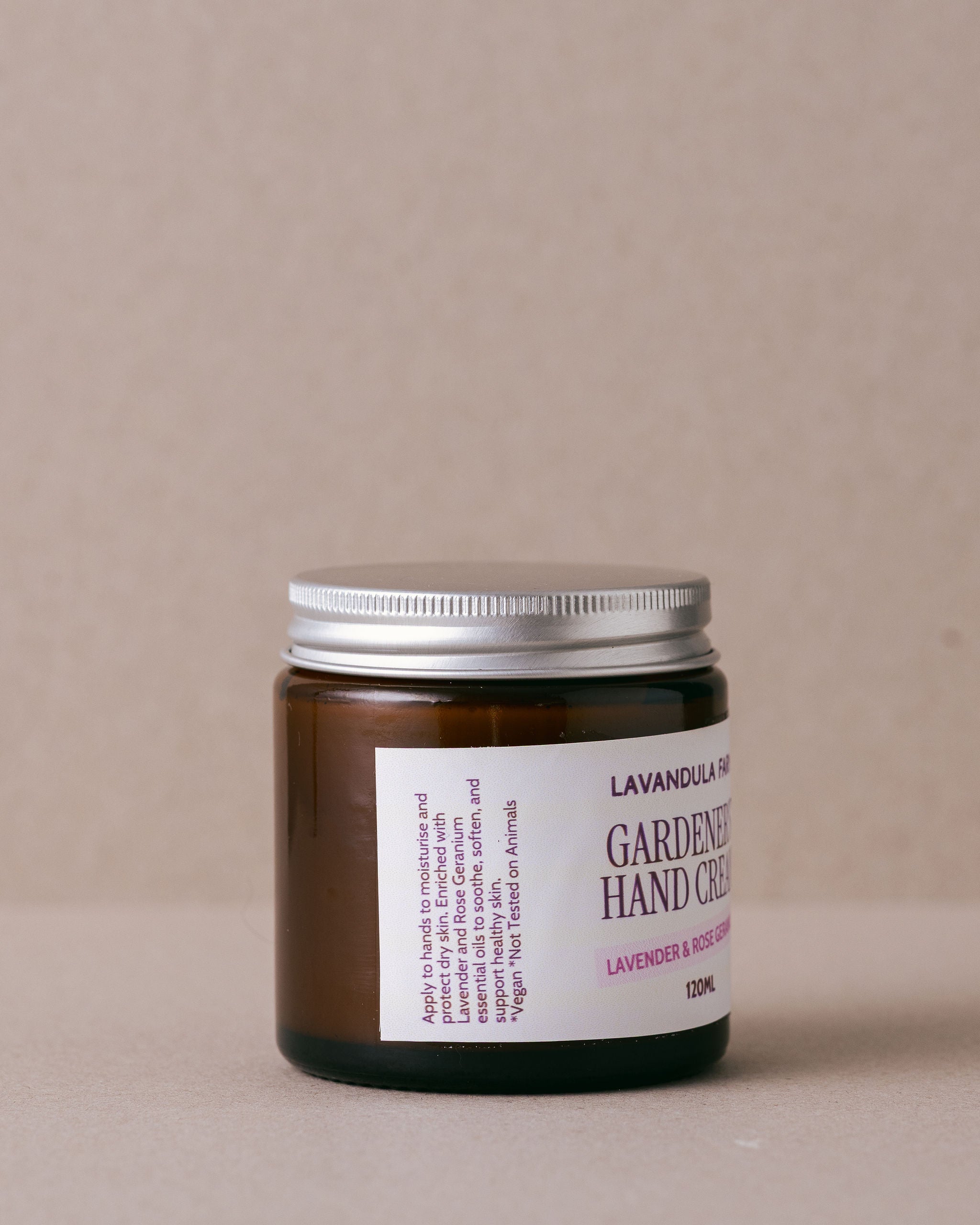 small glass jar of hand cream made with natural ingredients on a beige background