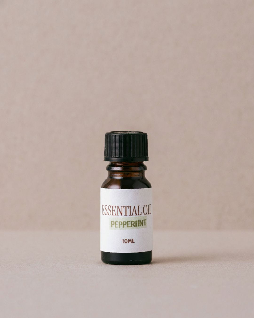 Peppermint essential oil bottle on a beige background