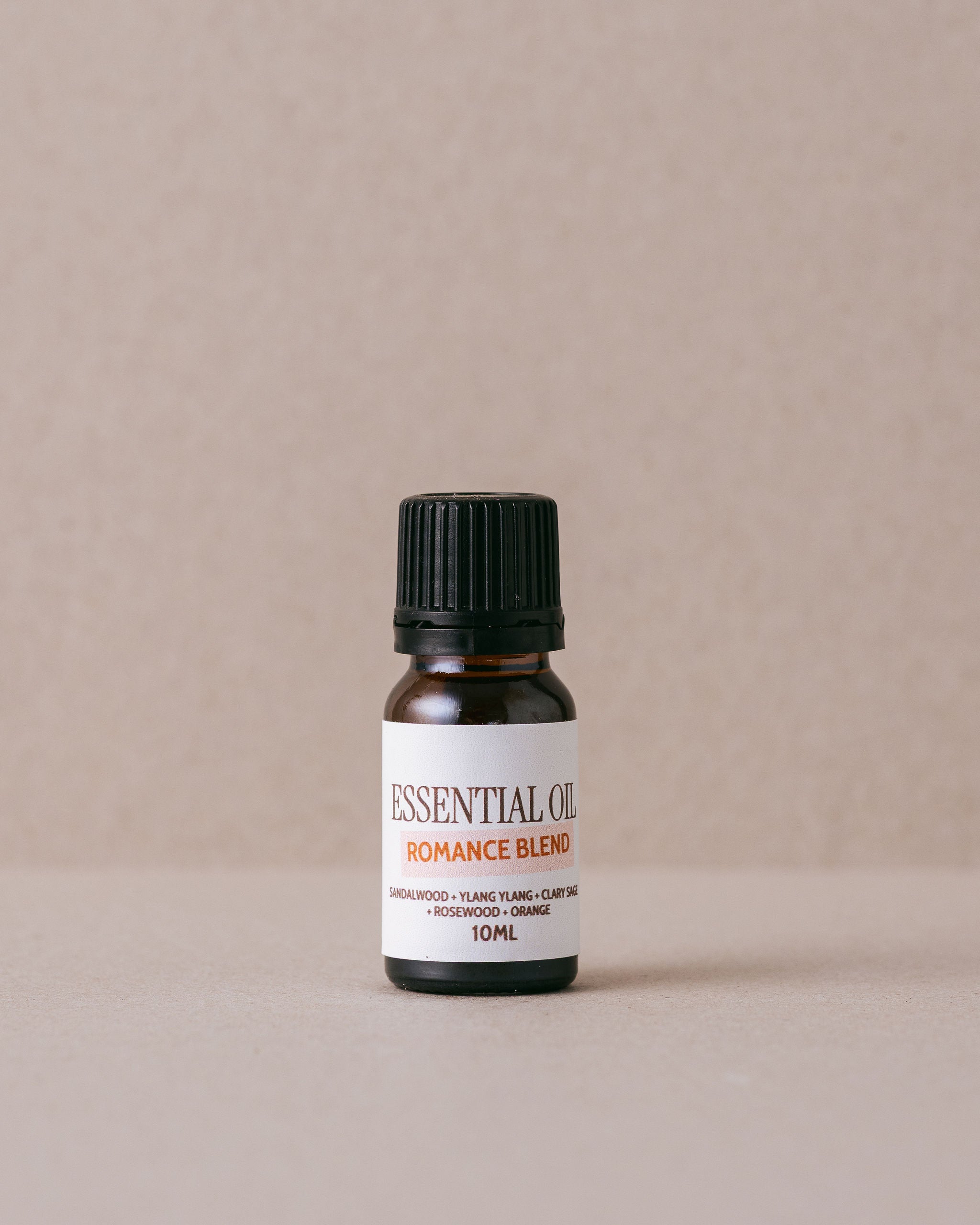 small glass bottle of essential oil on a beige background