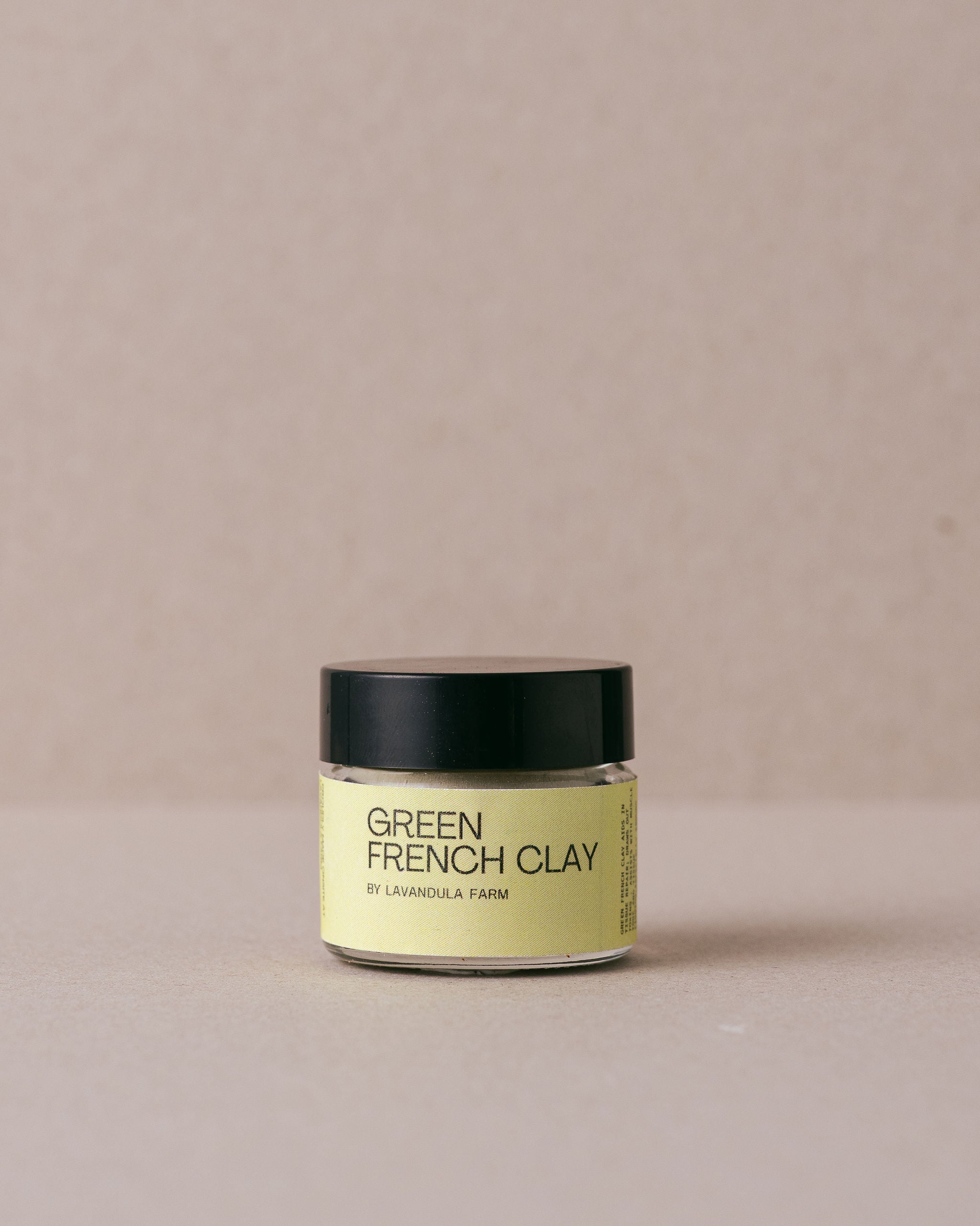 Jar of Green French Clay on a beige background