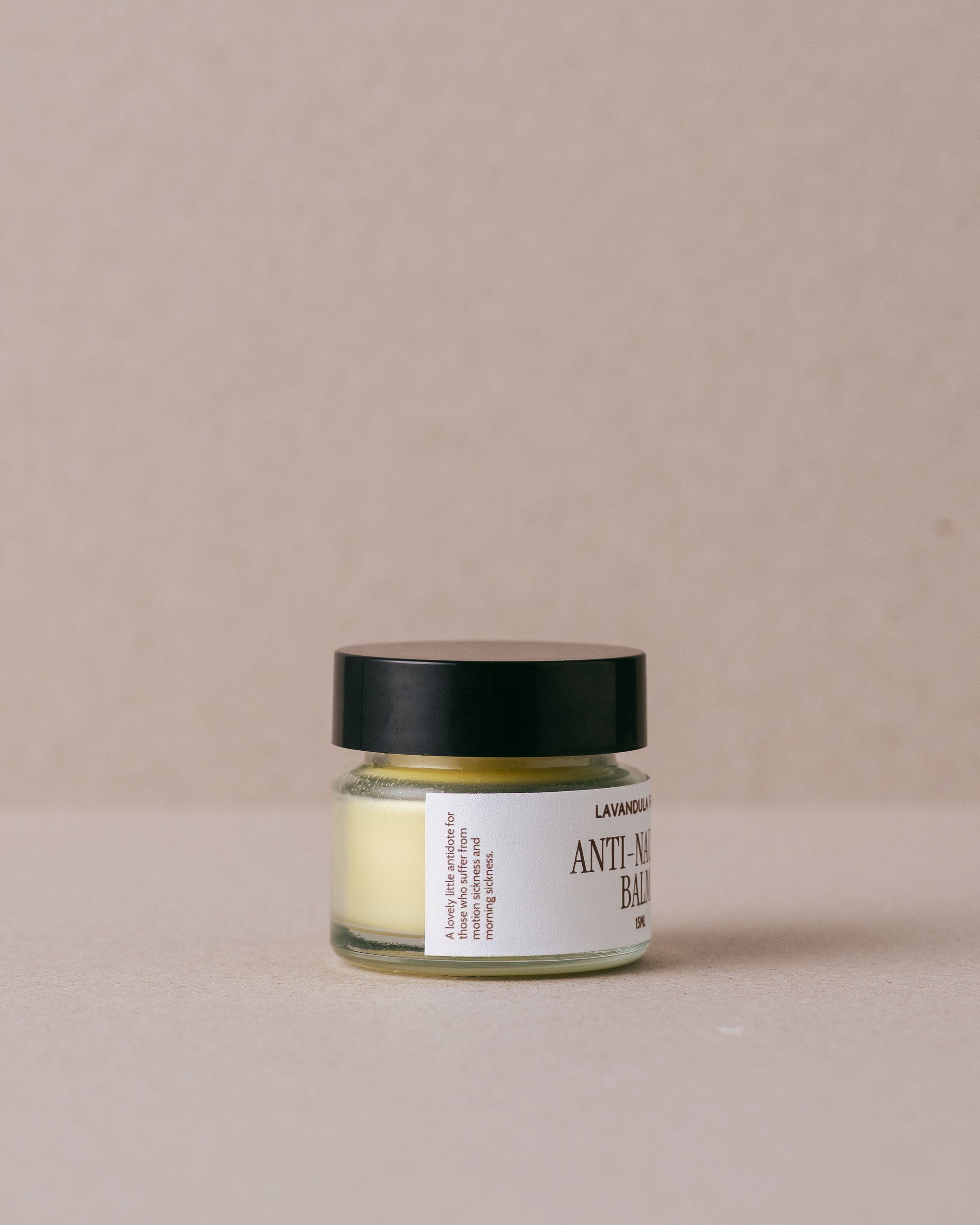 Jar of anti-nausea balm on a beige background