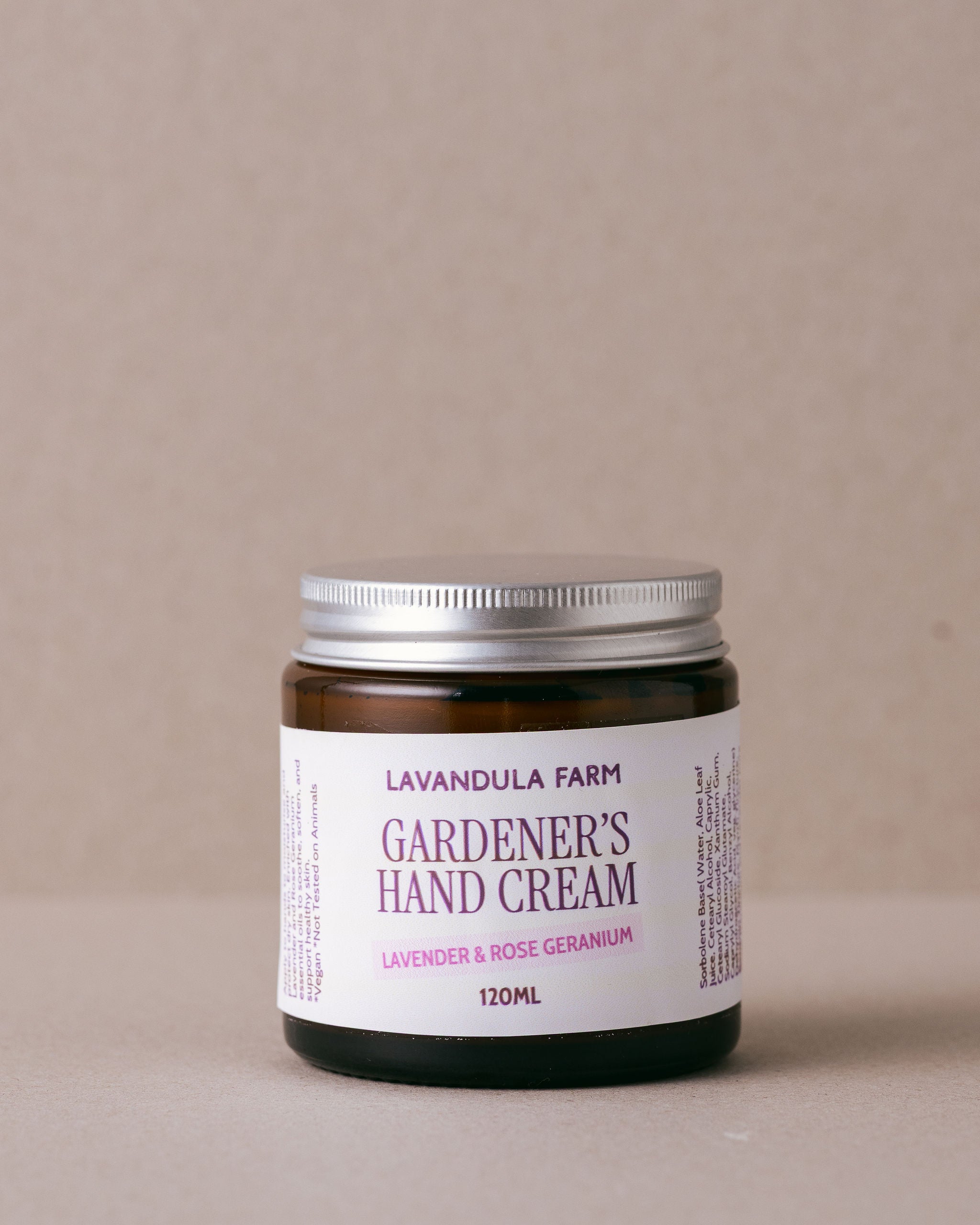 small glass jar of hand cream made with natural ingredients on a beige background