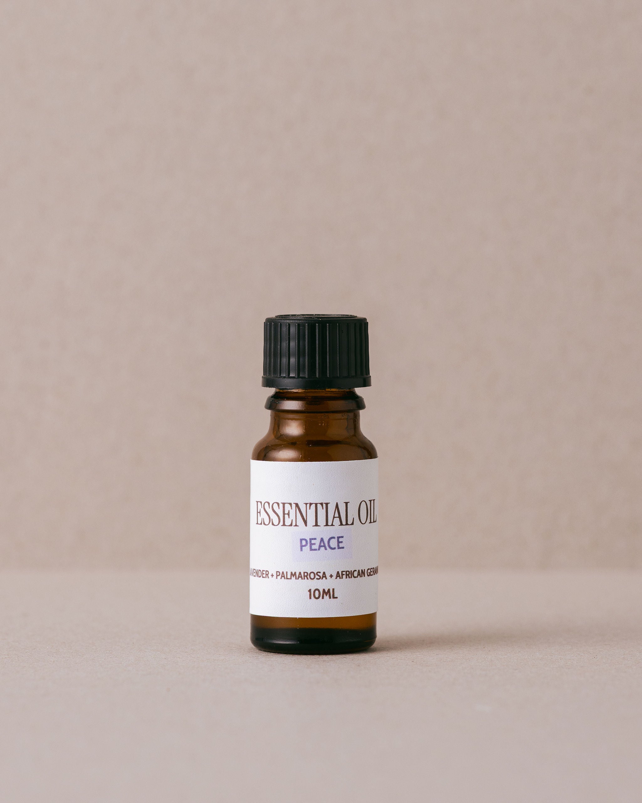 small glass bottle of pure essential oil on beige background
