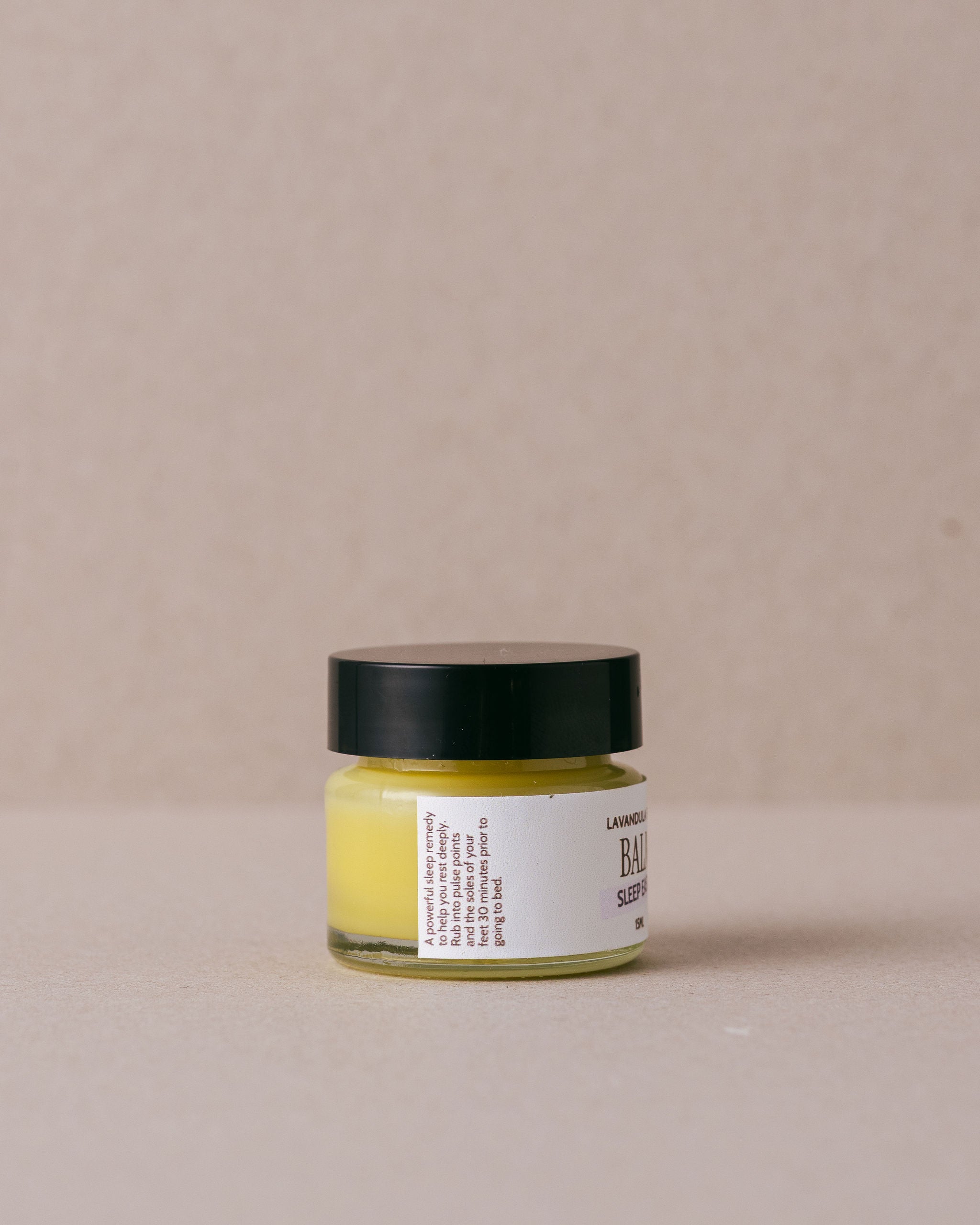 small glass jar of sleep easy balm made by Lavandula Farm on a beige background