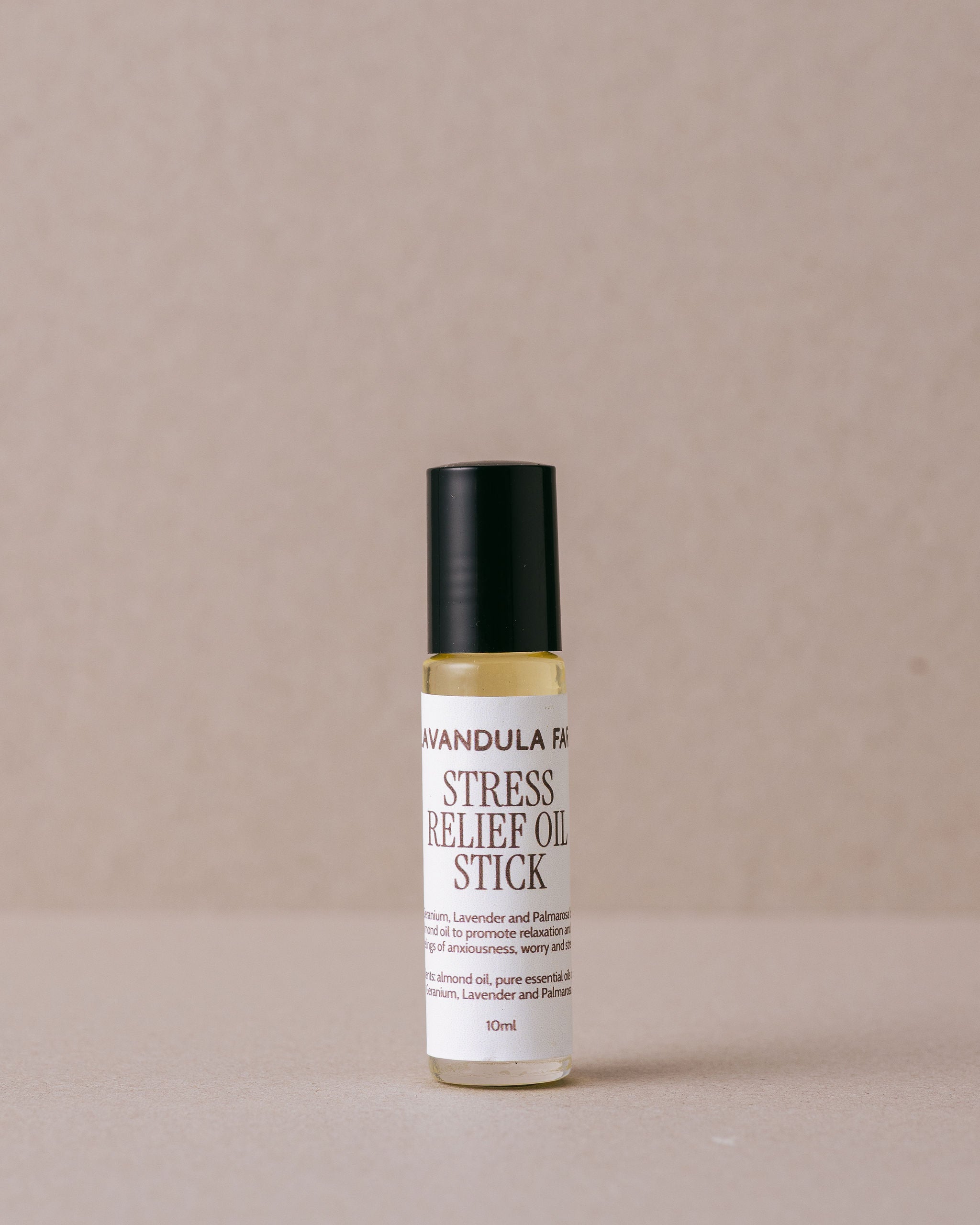 stres relief roll-on oil stick made by Lavandula Farm on a beige background