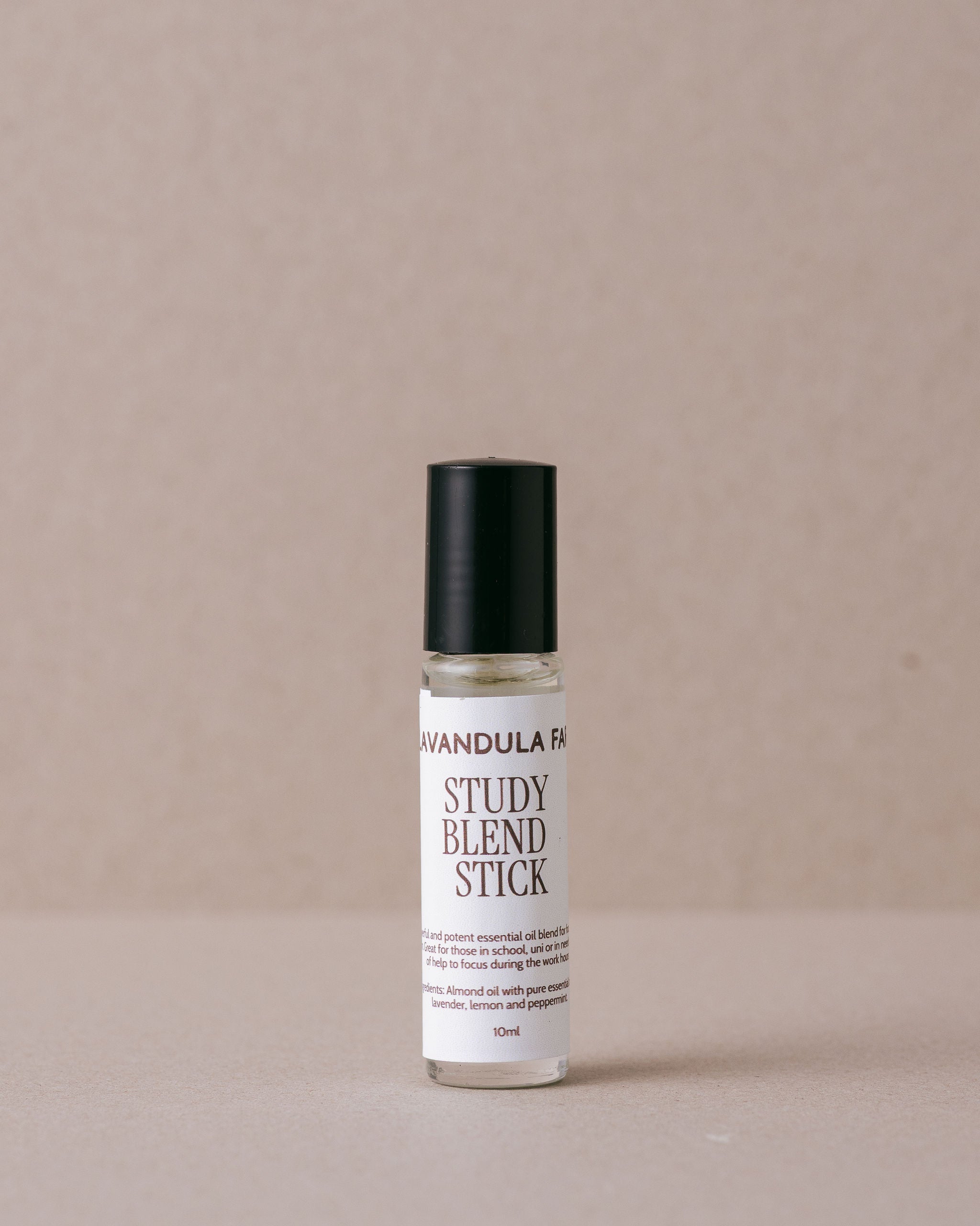 study blend oil stick in a glass roller made by Lavandula Farm on a beige background