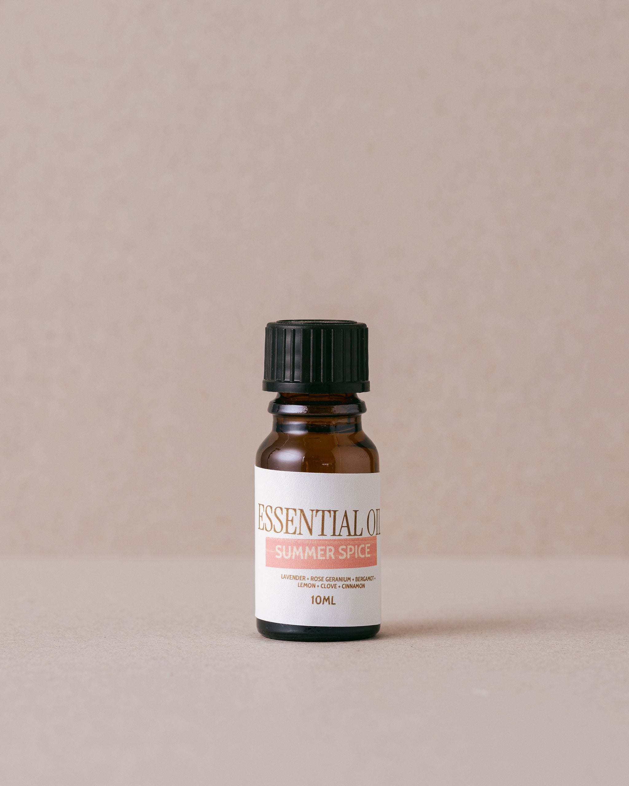 bottle of summer spice pure essential oil blend on a beige background