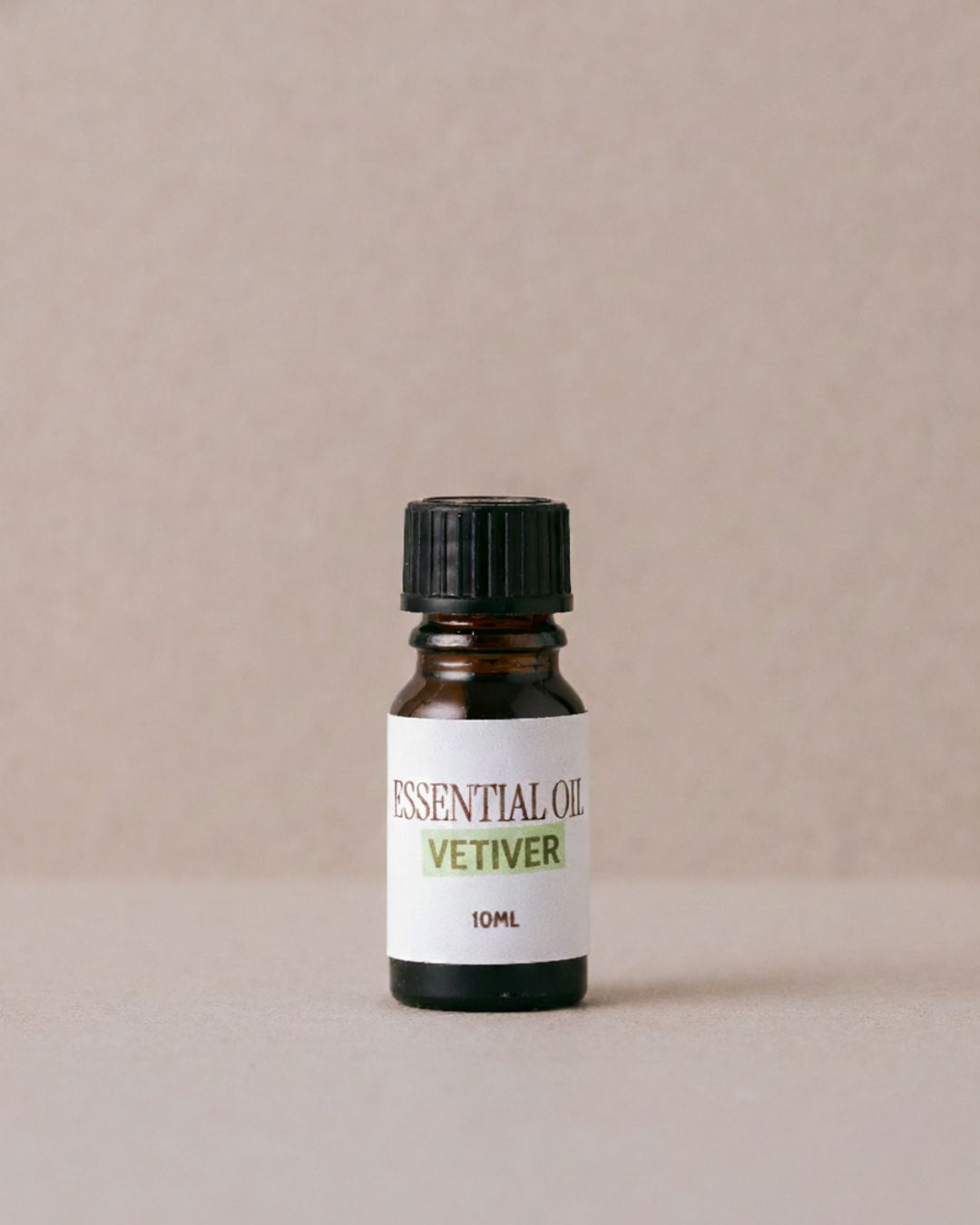 Bottle of essential oil labeled 'Vetiver' on a beige background